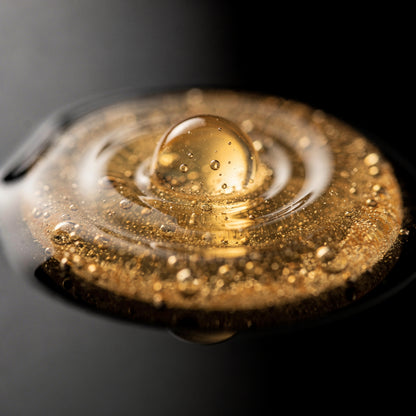 Textura ligera del sérum facial dorado